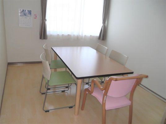 施設内の談話室の様子。複数名が座れるイスとテーブルが置かれている