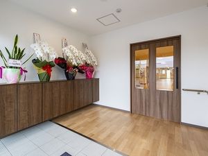 段差のないエントランス。大きな靴箱が置かれ、花も飾られている。
