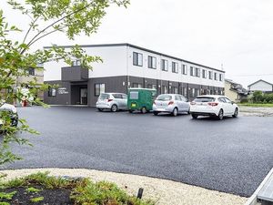 ２階建ての建物。玄関には屋根が付き、モノトーンで落ち着いた雰囲気。
