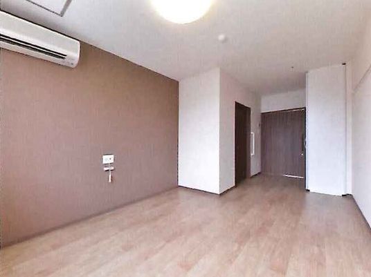 ワンルームタイプの小さな部屋の様子。エアコン、緊急コール、トイレや収納スペースがある部屋