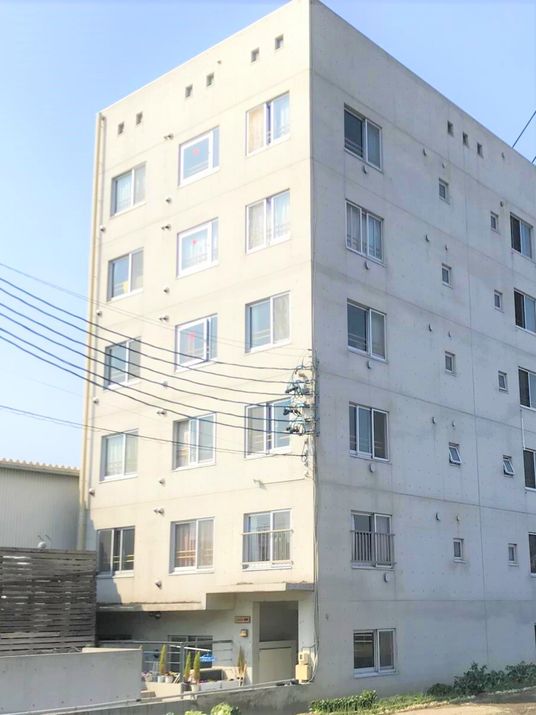 四角い直線的なデザインの施設の外観。5階建てのコスモス茜部を写したもの