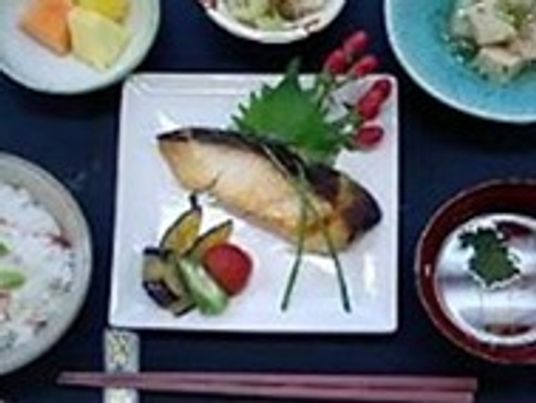 魚がメインの夕食メニュー。彩り豊かな食事の写真
