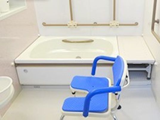 シャワーチェアが置いてある高齢者用の浴槽。腰かけた状態で入浴できるスペースを確保してあるのが分かる