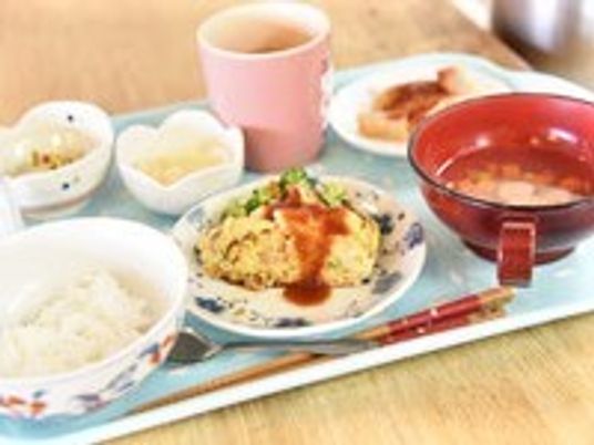 飲み物・ごはん・おかず・吸い物などがトレーに置かれているメニューの一例
