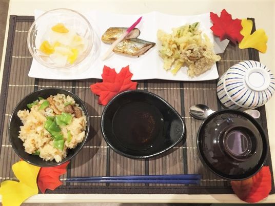 炊き込みご飯や汁物、茶わん蒸しや天ぷら、焼き魚などが並べられている。