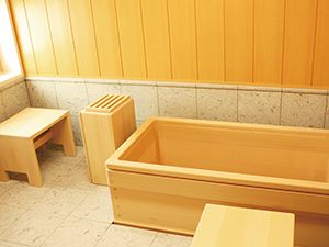 ヒバの木材で作られた浴槽が設置された浴室には木材がふんだんに使用され、窓が付き明るい雰囲気。