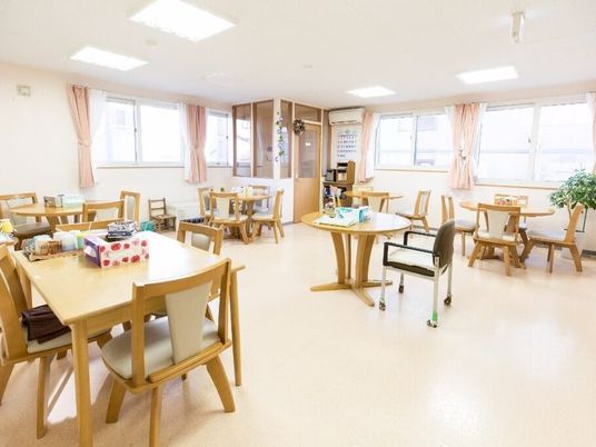四人掛けのテーブルと椅子が置いてある様子。施設内の広めのリビングスペース
