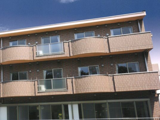 ブラウン系の建物はレンガ調の外壁で窓が多く、日当たりのいい場所に建っている。