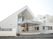 左側には手すり付きのスロープが設置された玄関があり、三角屋根が付いた建物がある。右側には白い大きな建物がある。