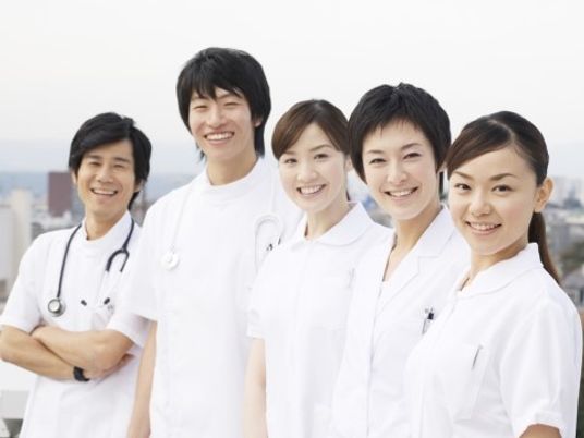 こちらを向いて姿勢を正しほほ笑んでいる医療従事者。医師と看護師の様子