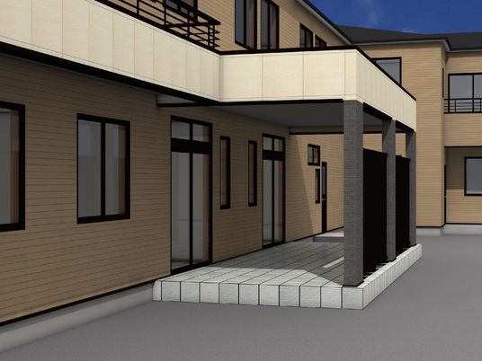 ブラウン系の建物は２階建て。玄関には二つの出入り口があり、敷地内には駐車スペースもある。