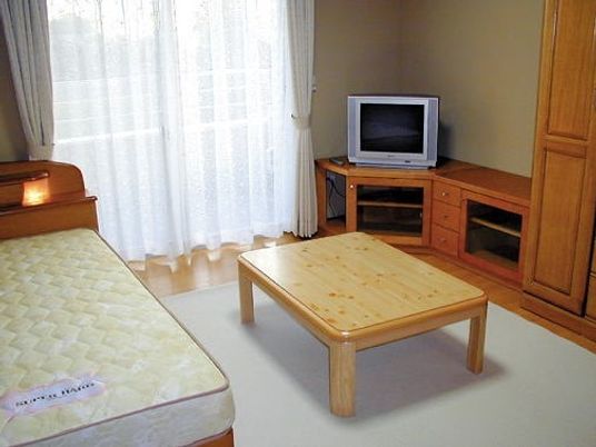 テレビやベッドが置いてある施設内の居室。家具付きの便利な部屋