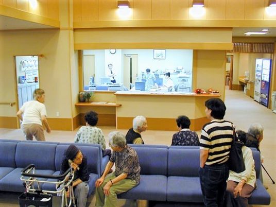 施設内の共有スペースでくつろいでいる高齢者。多くの人がソファに座っている様子