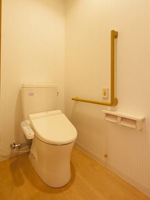 トイレにはエル字型の手すりやオレンジの呼び出しボタンが付いている。