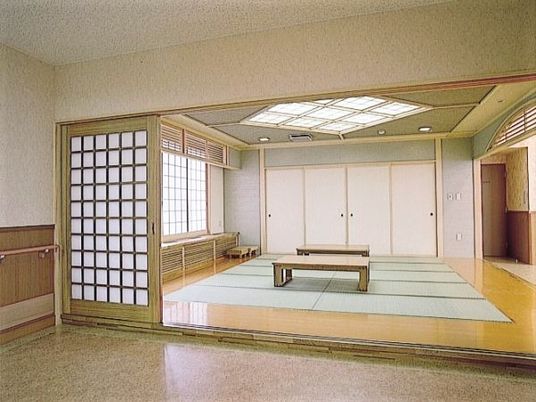 畳敷きの和室には障子が設置された窓があり、和風のテーブルが二つ並んでいる。