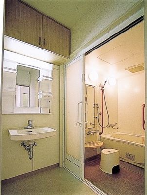 一人用の浴槽が置かれた浴室。手すりやシャワーも設置され、脱衣所もついている。