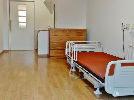 フローリングの部屋には介護ベッドが置かれ、ベッドサイドには緊急通報装置ベッドが付いている。