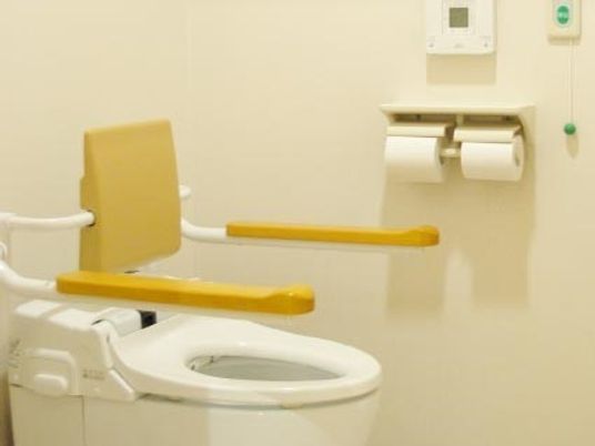 両側に手すりがついたトイレ。緊急時用のコールボタンも設置されている