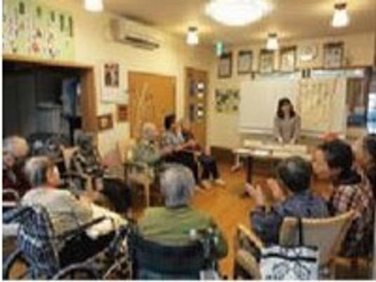 施設内の共有スペースに集まって催し物を楽しんでいる様子。施設内のレクリエーションの写真