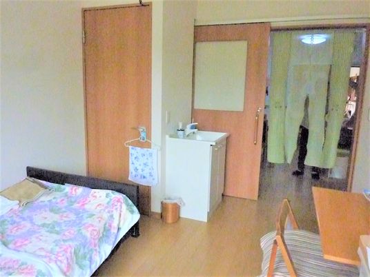 居室はベッドだけではなく、テーブルも配置され、暮らしに必要なものが揃っている