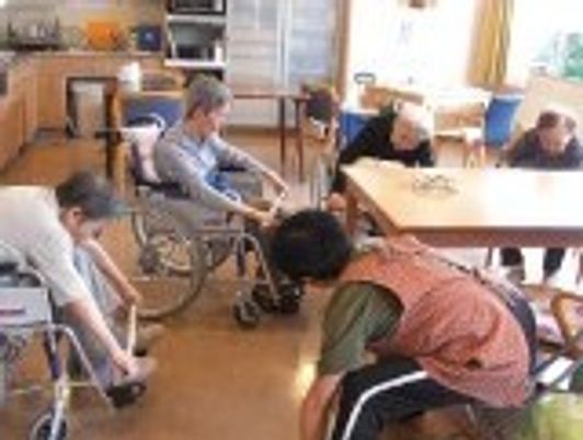 レクリエーションの体操に取り組んでいる人々。高齢者用施設の日常風景