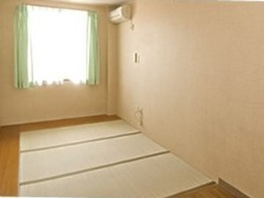 畳敷きの和室。エアコンや大きな窓が付き、明るい雰囲気。