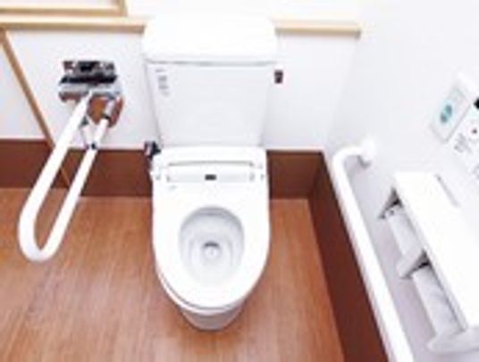 トイレの手すりが両サイドにつき、壁には呼び出しボタンも設置されている。