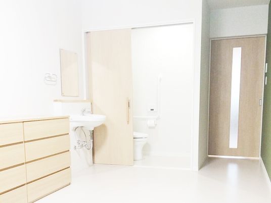 車いす対応のトイレや洗面所が付いた居室にはチェストもあり、明るい雰囲気。