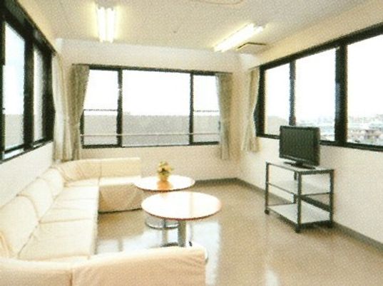 白い大きなソファが椅子を囲むようにしておかれ、テレビもあり、壁は窓となっている。