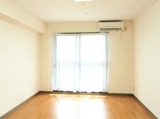 すっきりとしたシンプルな居室にはカーテン付きの大きな窓がある。