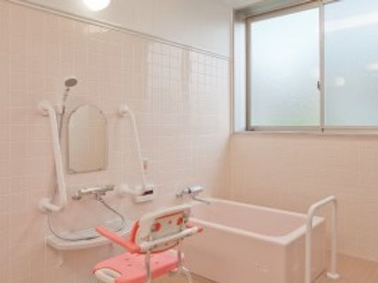 ピンク色のタイルが貼られた浴室には個浴やシャワーが設置されている。