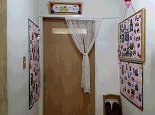 廊下の奥にある個室。両側の壁に写真や掲示物がある