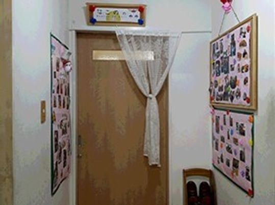 廊下の奥にある個室。両側の壁に写真や掲示物がある