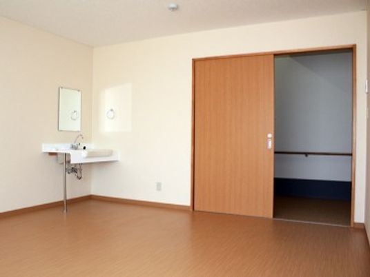 広めの部屋の住井洗面台がある様子。引き戸の入り口が写っている