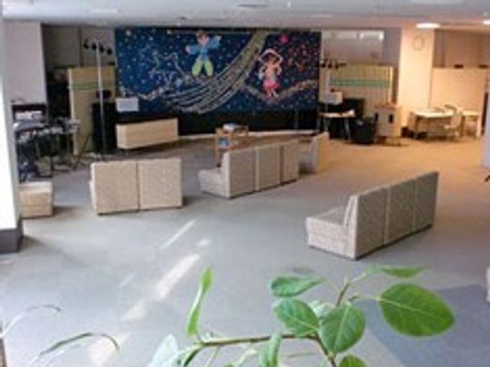 大きな掲示物とソファがたくさん並んでいる施設内のリラックススペース