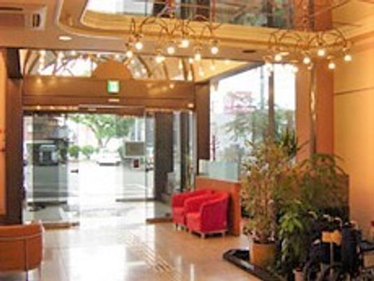 やわらかい照明がついている施設のエントランス。ソファや観葉植物が置いてある様子