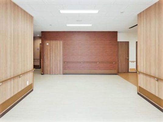 エントランスには余計なものがなく、幅の広い通路と木目調の壁が印象的。