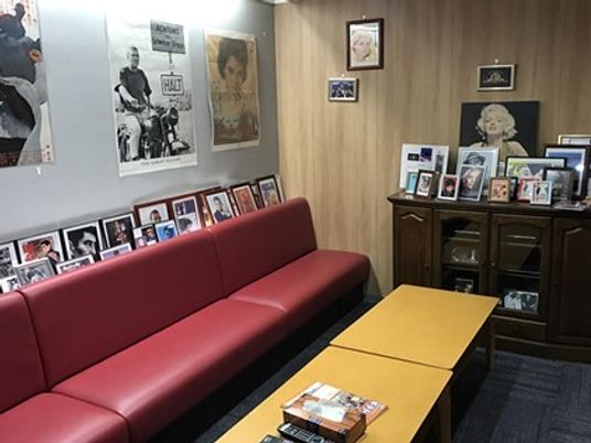 懐かしいハリウッドスターたちのポスターが貼られた室内には大きな赤いソファが置かれ、テーブルが置かれている。