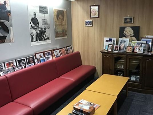 懐かしいハリウッドスターたちのポスターが貼られた室内には大きな赤いソファが置かれ、テーブルが置かれている。