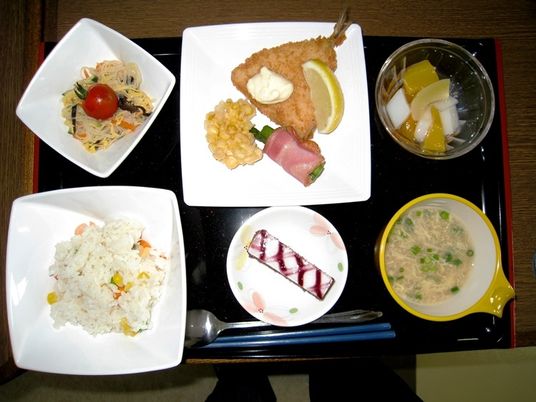 炊き込みご飯、2品のおかず、スープ、果物、デザートが盛り付けられたお膳