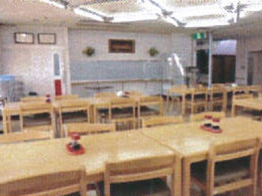 木製のイスとテーブルが並べられている食堂の様子。広めのホールの写真