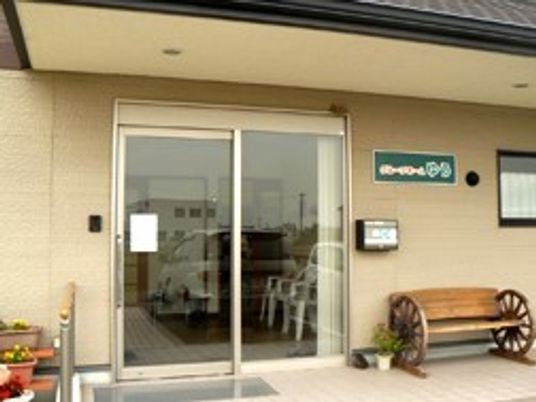 ホームの玄関周りには花や木製のベンチが置かれ、扉はきれいに磨かれている。