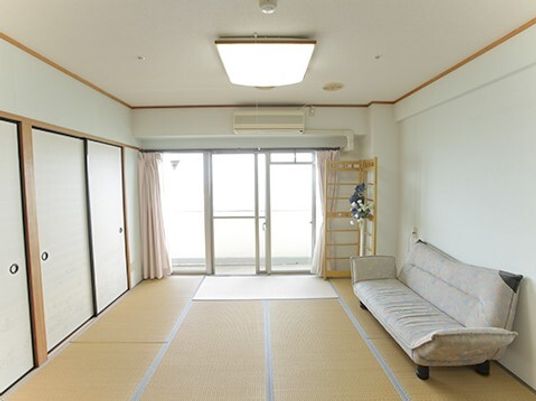 畳敷きの和室には家具や家電はなく、ソファベッドが置かれ、大きな窓が付いている。