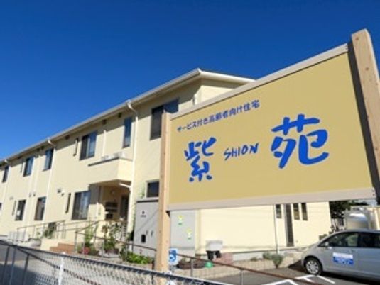 紫苑の文字が書いてある看板とその建物。マンション風の２階建ても建物がある