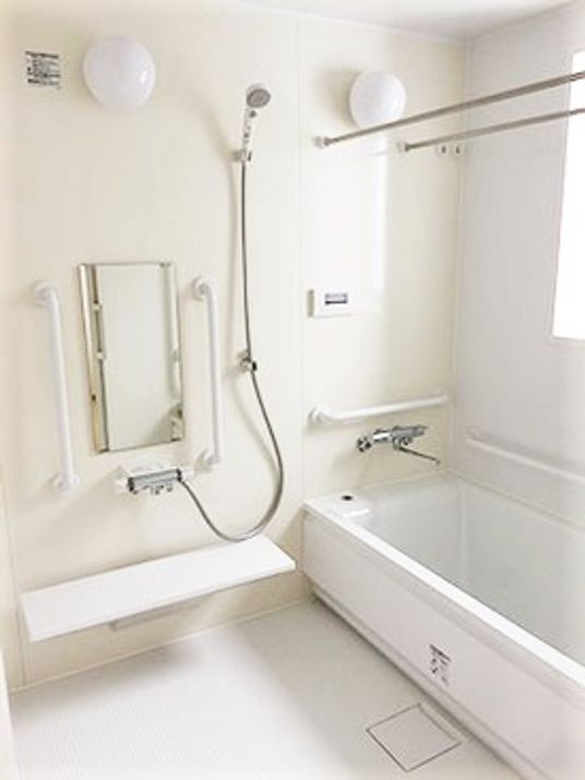 家庭によくあるサイズの浴室の写真。施設用の手すりがついている様子