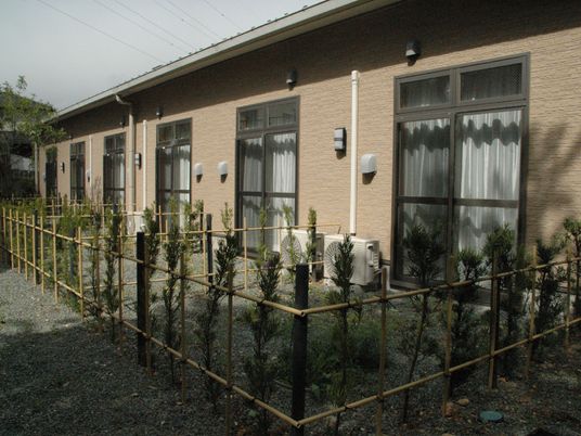 中庭に通じる部屋がある建物。整備された庭と建物の近影写真