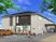 グレーを基調としたすっきりとした外観。2階建てで建物周辺には緑がある。