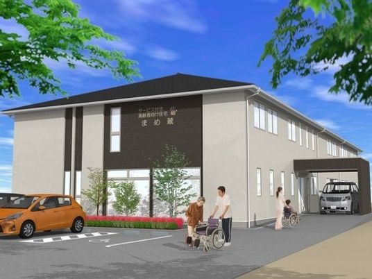 グレーを基調としたすっきりとした外観。2階建てで建物周辺には緑がある。
