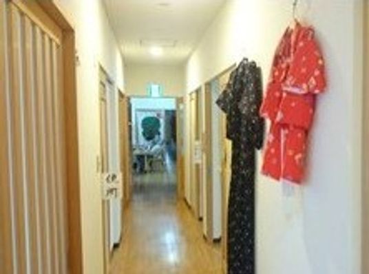 廊下には黒と赤の和風の服が飾られていて、「便所」と大きく書かれた紙が貼られている。