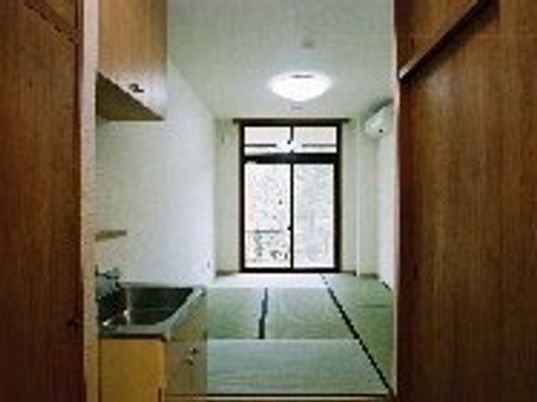 畳敷きの和室の部屋には大きな窓があり、エアコンや流しのような場所も付いている。